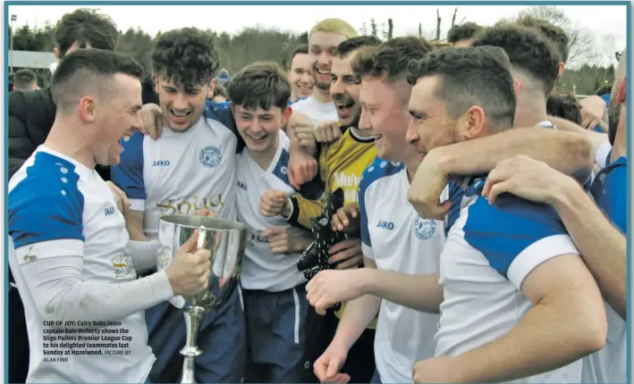  ?? ALAN FINN PICTURE BY ?? CUP OF JOY: Calry Bohs team captain Eoin Doherty shows the Sligo Pallets Premier League Cup to his delighted teammates last Sunday at Hazelwood.