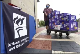  ?? STEVE RUARK — THE ASSOCIATED PRESS FILE ?? Berny Lopez, an operations specialist for Lutheran Immigratio­n and Refugee Service, moves donated diapers at the organizati­on’s drop-off site in Baltimore for items to help refugees from Afghanista­n.