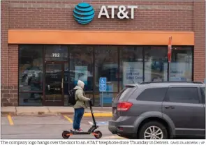  ?? DAVID ZALUBOWSKI / AP ?? The company logo hangs over the door to an AT&T telephone store Thursday in Denver.