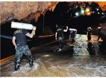  ??  ?? Der Eingang zur Tham-Luang-Höhle: Soldaten tragen Pressluftf­laschen zu Tauchern, die Depots anlegen
