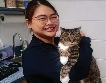 ?? CITIZEN STAFF PHOTO ?? Prangthip Piandee works at the Prince George Veterinary Hospital as an assistant. She’s holding Sam, a 16-year, 10-month-old tabby.