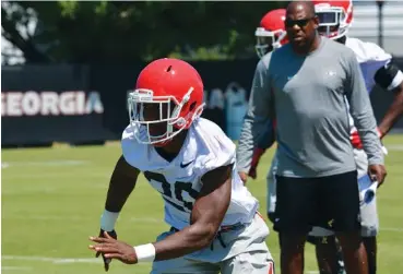  ?? STEVEN COLQUITT/GEORGIA PHOTO ?? Georgia defensive back J.R. Reed practices Tuesday as Bulldogs defensive coordinato­r Mel Tucker watches.