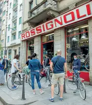  ?? (fotoserviz­io di Marco Passaro) ?? Nella foto grande, padre e figlio in bicicletta si trovano un’ auto in sosta vietata sulla ciclabili di Porta Venezia. A sinistra, altro traffico sulla nuova ciclabile all’altezza di corso Buenos Aires e l’ingresso dello storico negozio Rossignoli in corso Garibaldi: in questi giorni di Fase 2, lunghe code di chi ha voluto comprare o riparare la bici