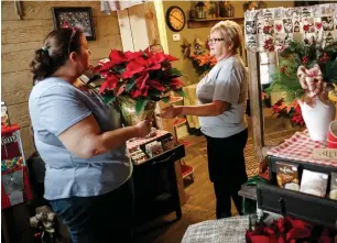  ??  ?? My LiTTLe Bakery and Coffee Shop: run by Lary and Malana Monson in Corning, ohio, USa in the picture, a Corning native Susan hern hands a poinsettia plant to Malana (left)over the holidays