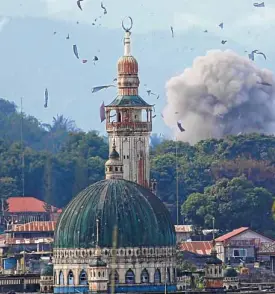  ?? —REUTERS ?? Smoke and debris mar the Marawi skyline as another bomb hits terrorist positions during an airstrike.