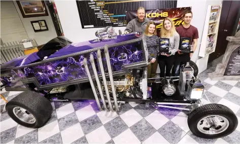  ?? DAN JANISSE ?? Gord Osborne, left, a transporta­tion technology teacher at Kingsville District High School, and students Paige Roddy, Grace Vermeulen and Alec Tonkin pose with Dragula 2.0 on Tuesday at the Canadian Transporta­tion Museum in Kingsville. The purple coffin dragster — based on a car from the TV show The Munsters — was built by about 80 students and won two awards at the Detroit Autorama show.