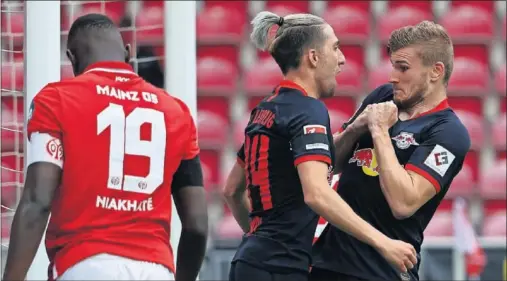  ??  ?? Timo Werner intenta evitar que Kevin Kampl le abrace tras uno de los goles de la victoria del Leipzig ante el Mainz.