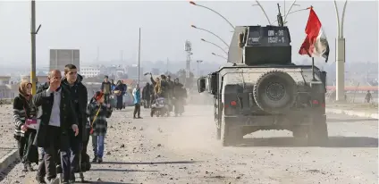  ?? – Reuters ?? LIBERATION: Civilians leave the city to escape from clashes during a battle with IS militants, in Al Zirai district in Mosul, Iraq, on Wednesday.