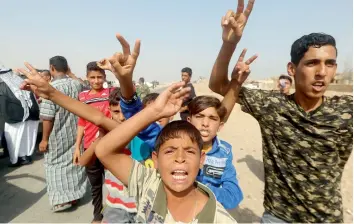  ??  ?? TOGETHER AGAIN: Iraqi youth flash the sign of victory as they congratula­te members from the Popular Mobilisati­on units fighting alongside Iraqi forces, after they ousted Daesh from Tikrit in October. — AFP