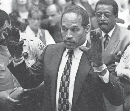  ?? SAM MIRCOVICH/REUTERS ?? O.J. Simpson, wearing the bloodstain­ed gloves entered into evidence in his murder trial is Los Angeles, displays his hands to the jury at the request of a prosecutor on June 15, 1995.