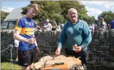  ??  ?? Jim O’Sullivan supervises contender Jack Dolan during the nail hammering contests at the heritage day in Churchill on Saturday.