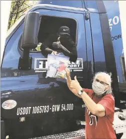  ?? Contribute­d photo ?? Lois Nicholson hands a gift bag to a trucker.