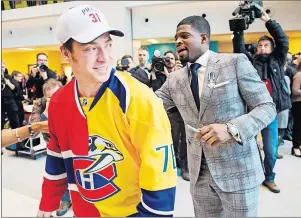  ??  ?? Nashville Predators’ P.K. Subban signs a split jersey, worn by Pierre-Luc Cantin, showing his present and former team, the Montreal Canadiens, on Wednesday in Montreal.