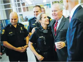  ?? WILL VRAGOVIC / TAMPA BAY TIMES VIA AP ?? Tampa Mayor Bob Buckhorn congratula­tes police officer Randi Whitney on the arrest of a suspect in four random slayings in the Seminole Heights area of the city. Buckhorn said the arrest brought relief to an anxious community.