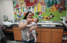  ?? RICK BOWMER — THE ASSOCIATED PRESS ?? Elizabeth Amador bottle feeds her daughter Destinee, 9months, at the Ellis R. Shipp Public Health Center in West Valley City, Utah, on Thursday.