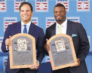  ?? MIKE GROLL/ASSOCIATED PRESS ?? Baseball Hall of Fame inductees Mike Piazza, left, and Ken Griffey Jr., hold their plaques after Sunday’s ceremony.