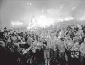  ??  ?? Croatian fans in Zagreb, Croatia, cheer while watching the semifinal match between Croatia and England at the 2018 soccer World Cup, on Wednesday.