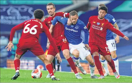  ??  ?? Everton's Icelandic midfielder Gylfi Sigurdsson (C) vies for the ball against Liverpool's Alex Oxlade-Chamberlai­n (R) and Jordan Henderson (2nd L) at Goodison Park on Sunday