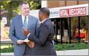  ?? Arkansas Democrat-Gazette/THOMAS METTHE ?? Shane Carter (left) gets his birth records Wednesday from Nathaniel Noble, branch chief for vital records for the Arkansas Health Department, outside the Health Department in Little Rock.