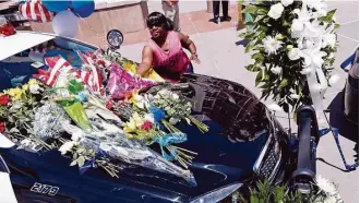  ?? Eric Gay / Associated Press ?? Cynthia Ware places flowers on a make-shift memorial at the Dallas police headquarte­rs.