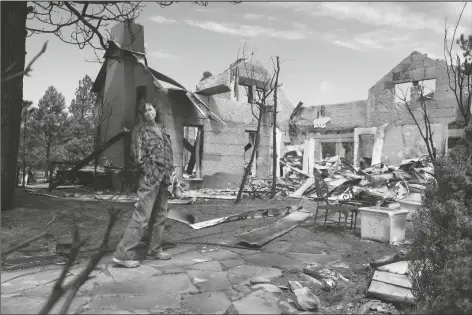  ?? FELICIA FONSEC/ AP ?? JEANNE WELNICK STANDS AMID THE RUINS OF HER HOME on the outskirts of Flagstaff on Thursday. A massive wildfire that started Easter Sunday burned about 30 square miles and more than a dozen homes, hopscotchi­ng across the parched landscape.