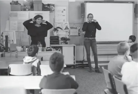  ?? MARKUS SCHREIBER PHOTOS/THE ASSOICATED PRESS ?? Sandra Wiandt, right, and a teacher’s aide lead a "Willkommen­sklasse" at a Berlin elementary school, one of 478 such welcome classes in the capital.