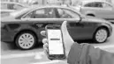  ?? ANDREW CABALLERO-REYNOLDS/GETTY-AFP ?? An UBER app is viewed as cars drive by in Washington, D.C.