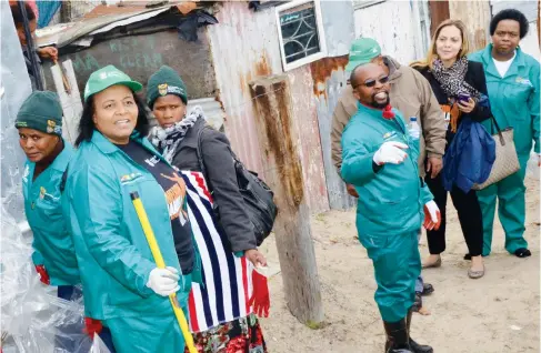  ??  ?? Minister of Environmen­tal Affairs, Mrs Edna Molewa cleaning the streets of Khayelitsh­a during one of the clean-up campaigns by the Department. Image by Tshego Letshwiti.