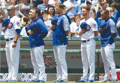  ??  ?? Addison Russell ( right) stands with teammates during the national anthem Friday, but he didn’t play against the Rockies. | AP