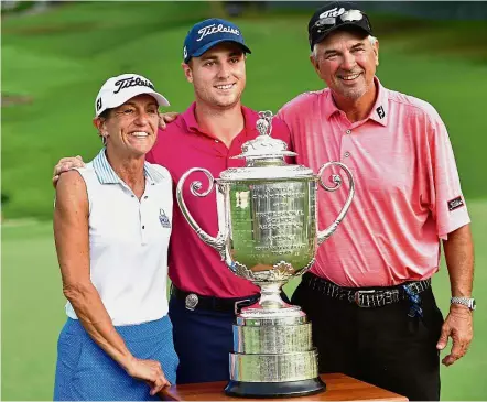  ?? — AFP ?? Always an inspiratio­n: American Justin Thomas and his parents, Mike (right) and Jani, posing with the Wanamaker Trophy at Quail Hollow on Sunday.