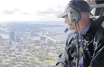  ?? JOHN RAOUX/ASSOCIATED PRESS ?? Gov. Rick Scott flies over Jacksonvil­le in a military helicopter on Tuesday, assessing damage from Hurricane Irma.