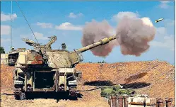  ?? AFP ?? Israeli soldiers fire a 155mm self-propelled howitzer towards the Gaza Strip from the southern Israeli city of Sderot on Thursday. Hamas sent a heavy barrage of rockets deep into Israel and Israel pounded Gaza with more airstrikes as tensions continued to escalate.