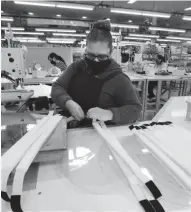  ?? RICK WOOD / MILWAUKEE JOURNAL SENTINEL ?? Olympus Group employee Margarita Garcia sews the straps for clear plastic protective face shields on Friday.