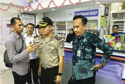  ?? GALIH WICAKSONO/JAWA POS ?? CEK KETERSEDIA­AN MASKER: Kapolres Gresik AKBP Kusworo Wibowo didampingi Kepala Dinkes Pemkab Gresik drg Syaifuddin Ghozali (kanan) melakukan inspeksi mendadak ke sejumlah apotek di wilayah perkotaan kemarin sore.