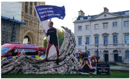  ?? ?? A 4-meter-high installati­on, depicting Mark Zuckerberg surfing on a wave of cash and surrounded by teenagers, outside the Houses of Parliament in London. Photograph: Steve Parsons/PA