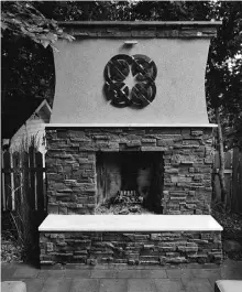  ??  ?? A Celtic pattern, like that on the yard gates, graces the wood-burning fireplace anchoring the patio.