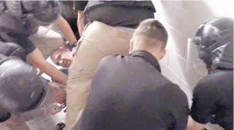  ?? SOURCE: MDC ?? Correction­s officers subdue Vicente Villela at the Metropolit­an Detention Center on Feb. 2 in this screenshot from recently released video of the incident. Villela died, and the case has been turned over to the District Attorney’s Office.