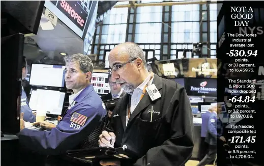  ?? Spencer Platt / Getty Images ?? Traders work Friday on the floor of the New York Stock Exchange. A rout in global stock markets started in Asia and spread to Europe and the U.S.