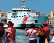  ??  ?? The Italian coast guard vessel sails into port in Sicily