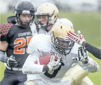  ?? BOB TYMCZYSZYN/STANDARD STAFF ?? Josh Ferguson makes one of his several runs as the Sir Winston Churchill Bulldogs played host to the Stamford Hornets in high school football action Friday. Stamford Austin’s Price tries to make the tackle.