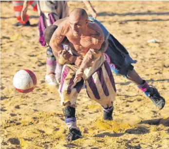  ?? FOTOS: COMUNE DI FIRENZE/ SCHENK ?? Zwei Mannschaft­en kämpfen verbissen um den Ball, um den Sieg und die Ehre – das hat der „Calcio Storico“mit einem ganz normalen Fußballtur­nier gemein. Allerdings stehen in Florenz jeweils 54 Männer auf dem Sandplatz. Die Spielkleid­ung orientiert sich...