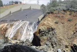  ?? Bill Husa Associated Press ?? OROVILLE DAM’S eroded concrete spillway is inspected via helicopter after engineers shut off the water f low. The top priority is to clear out rocks and debris.