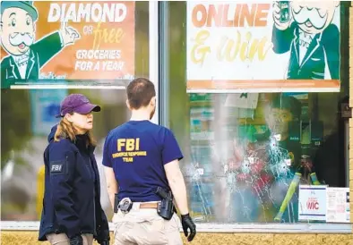  ?? MATT ROURKE AP ?? Federal investigat­ors survey the scene of Saturday’s mass shooting at a Tops supermarke­t in Buffalo, N.Y.