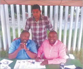  ??  ?? Globetrott­er... Denna (standing) signs his profession­al contract with PSL outfit Jomo Cosmos’ Bro J, with local players’ agent Collin April running an eye over proceeding­s.