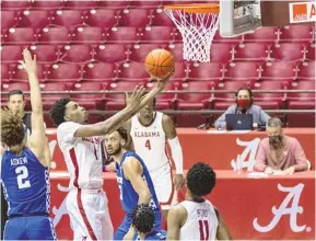 ?? VASHA HUNT/ASSOCIATED PRESS ?? Alabama guard Herbert Jones (1) narrowly missed getting a triple-double during a victory against Kentucky on Tuesday night. Defending is UK’s Devin Askew (2).