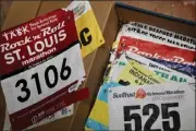  ?? ?? David Bergeron shows some of the race bibs he has accumulate­d over 39 years of marathons he has entered. His first marathon was here at home in Long Beach in 1984.