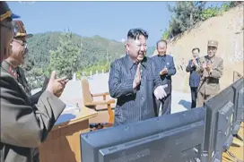  ?? KRT VIA AP VIDEO ?? This image made from video of a news bulletin on Tuesday shows what was said to be North Korean leader Kim Jong Un (center) applauding after the launch of a Hwasong-14 interconti­nental ballistic missile in North Korea’s northwest.