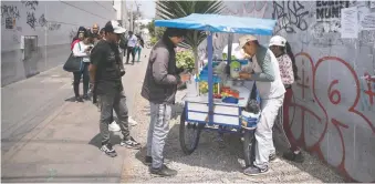  ?? ?? Percy Mendoza, a street ceviche vendor, works selling food from his mobile stall in Lima.