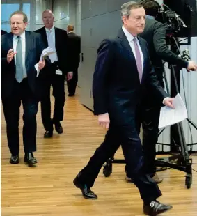  ??  ?? Eurotower Mario Draghi, presidente della Bce, si avvia al tavolo della conferenza stampa di ieri a Francofort­e. Alle sue spalle, a sinistra nella foto, il vicepresid­ente uscente della Banca centrale, Vitor Constancio Le decisioni di politica monetaria