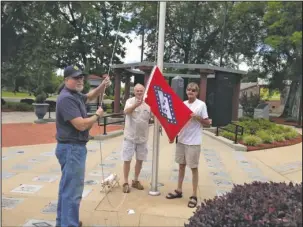  ?? Submitted photo ?? GETTING READY: From left, Veterans Memorial Committee members Mike Sharp, Jackie Davis and Walt Thrasher ready the Arkansas flag as they make preparatio­ns for the Memorial Day ceremony set to begin at 11 a.m. Monday at the Garland County Veterans...